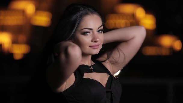 Sexy brunette woman posing at the night touching black hair - Záběry, video