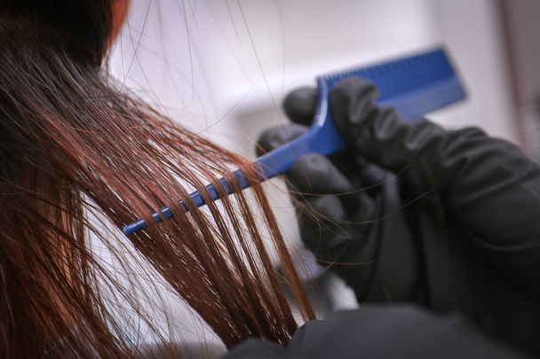 Girl in beauty salon while an hair stylist dyeing her hair - Foto, imagen