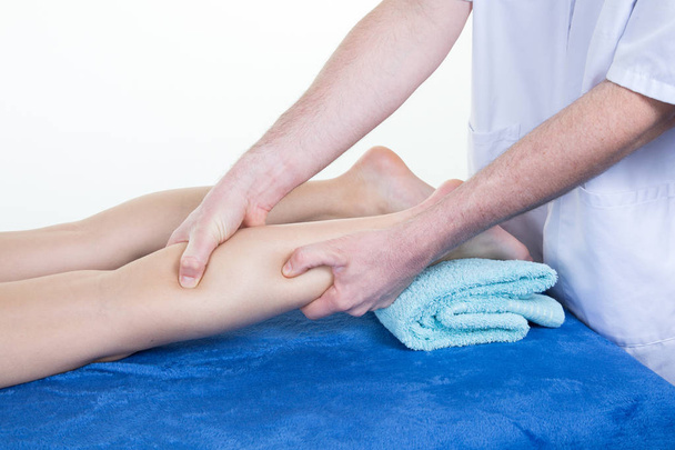 Druk kalf massage van vrij slank meisje door de therapeut van - Foto, afbeelding