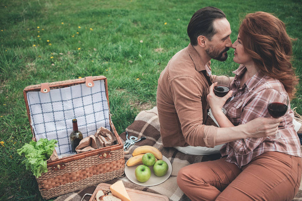 Happy loving couple having romantic picnic in the nature  - Фото, изображение