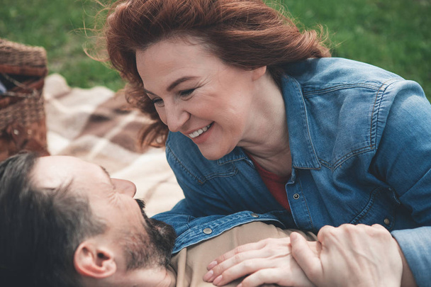 Glad woman looking into man eyes with love outdoor  - Photo, image