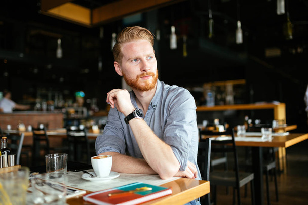 Poważny człowiek młody, picia kawy w kawiarni - Zdjęcie, obraz
