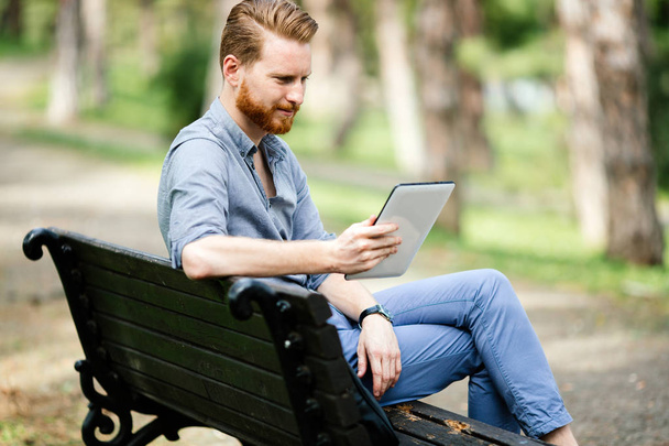 Businessman using tablet pc in park and relaxing - Foto, immagini