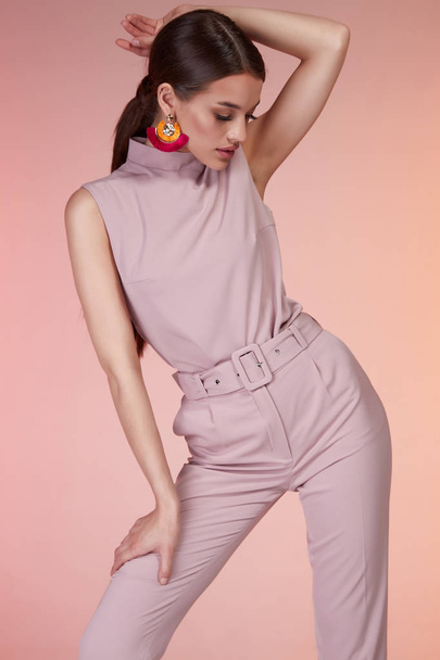 Pretty beautiful sexy elegance woman fashion model glamour pose wear pink color trousers silk blouse suit clothes party summer collection makeup office hair style brunette success accessory jewelry. - Foto, imagen