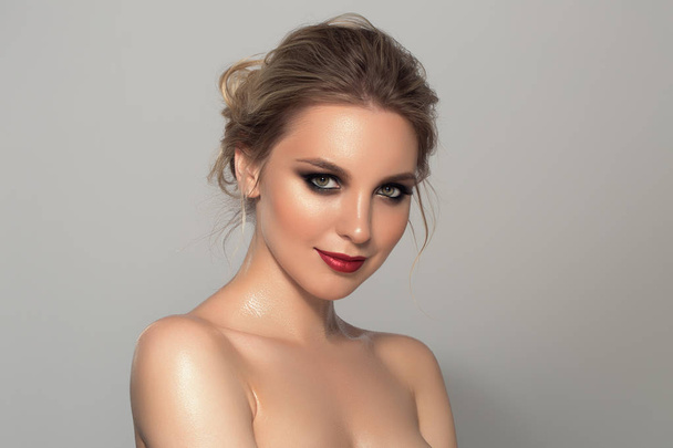 Beauty portrait of model with trendy make-up. Fashion shiny highlighter on skin, sexy gloss lips make-up. Photo on a light background. - 写真・画像