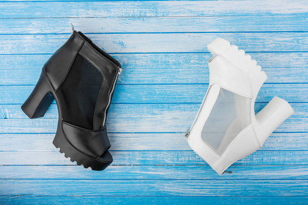 Elegantní moderní vysoký podpatek žena bílé a černé kožené boty s pouta na modré a bílé kontrastní pozadí vrcholový úhel - Fotografie, Obrázek