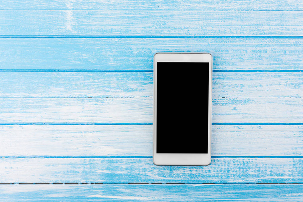 Telefone esperto branco da tela grande com reflexão no ângulo superior do fundo de madeira azul e branco do contraste alto
 - Foto, Imagem