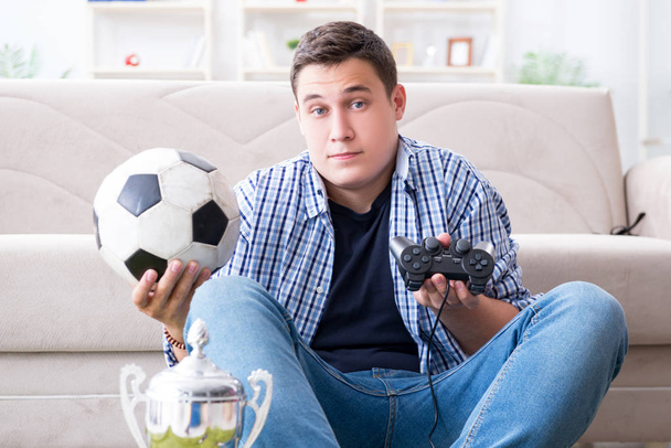 Молодой человек играет в компьютерные игры дома - Фото, изображение