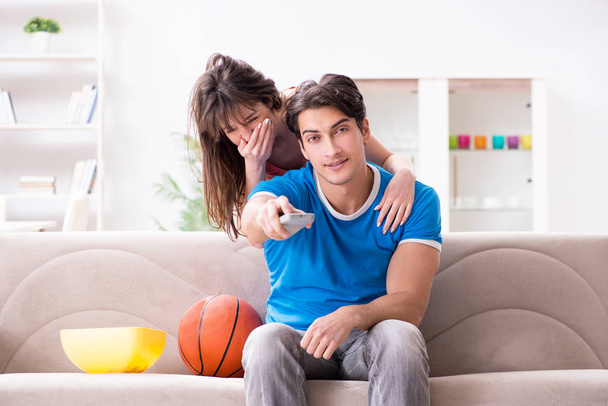 Man watching basketball with his wife - 写真・画像