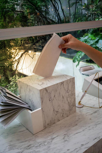 Nahaufnahme einer Person beim Einwerfen von Briefen in den Luxus-Briefkasten - Foto, Bild