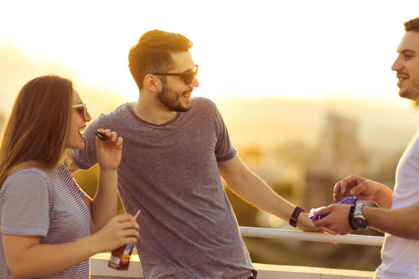 Gruppo di giovani amici bianchi che si rilassano sulla terrazza durante l'estate
 - Foto, immagini