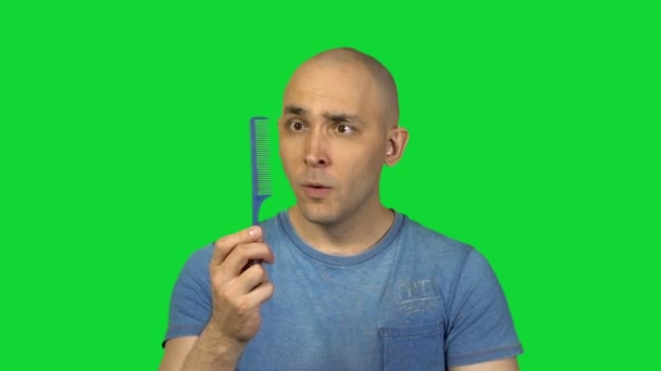 Kartáč na vlasy a holohlavý muž na zeleném pozadí - Záběry, video