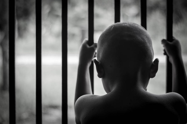  criança segura gaiola com triste e sem esperança, Vítimas de tráfico de seres humanos, Violência contra as crianças; Dia Internacional Antitráfico
 - Foto, Imagem