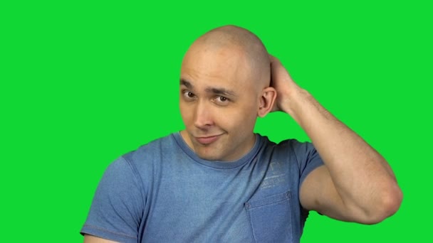 Dotykając głowy łysy mężczyzna na zielonym tle - Materiał filmowy, wideo