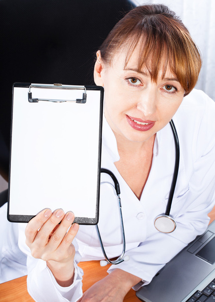 Female doctor showing blank clipboard - Fotó, kép
