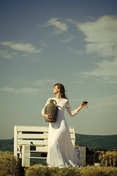 Young wine. Girl in white dress posing on blue sky - Φωτογραφία, εικόνα