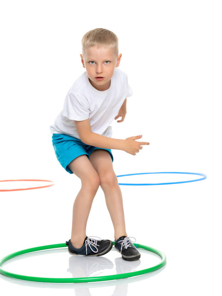A little boy is playing with a hoop. - Foto, Bild