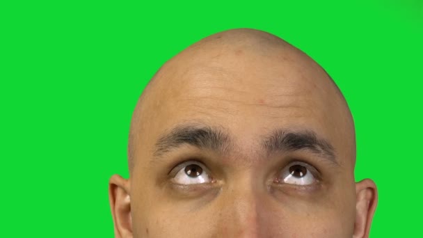 Holohlavý muž s polovinu tváře na zeleném pozadí - Záběry, video