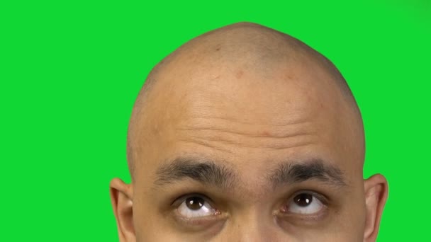 Łysy mężczyzna i pół twarzy na zielonym tle - Materiał filmowy, wideo