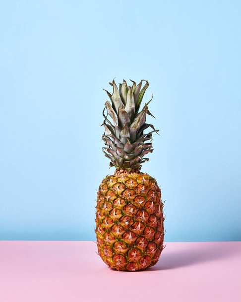 ízletes trópusi ananász, kék és rózsaszín háttér  - Fotó, kép