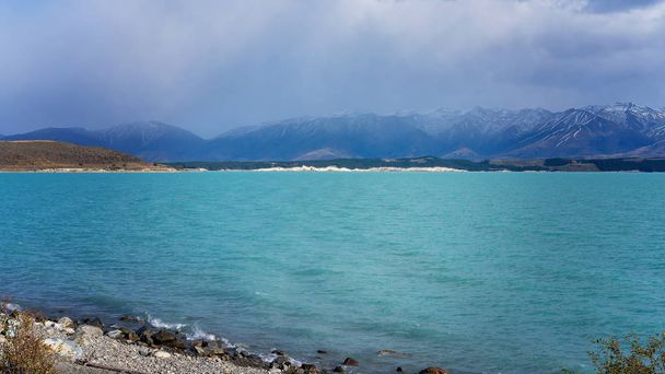The Topaz Blue Water And Snow Capped Mountains of Lake Pukaki in New Zealand
 - Фото, изображение