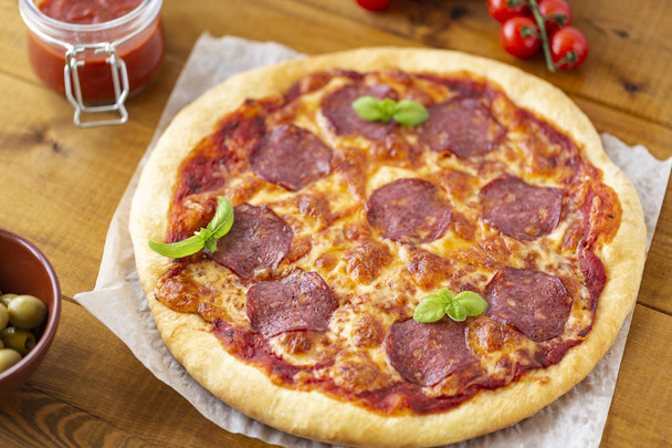 rustik pizza salam, mozzarella, zeytin ve fesleğen ile. - Fotoğraf, Görsel