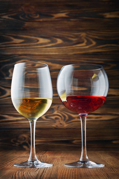 Pár brýle s červenou a bílého vína pro degustaci na dřevo textury pozadí - Fotografie, Obrázek