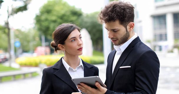 Un par de personas de negocios que utilizan una tableta al aire libre - Foto, Imagen