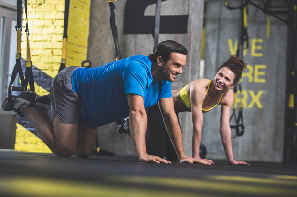 Positive male and woman doing workout - Photo, Image