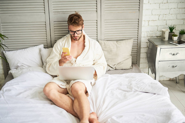 Focused attractive male working with gadgets in morning - Fotó, kép