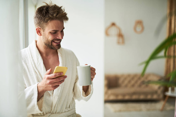 Satisfied man spending morning in hotel room - Фото, зображення