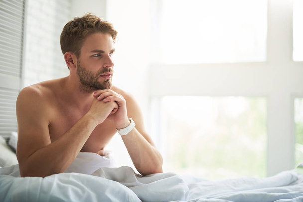 Attractive thoughtful man considering arrangements after waking up - Foto, immagini
