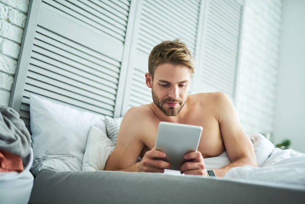 Relaxed man chatting online in morning - Valokuva, kuva