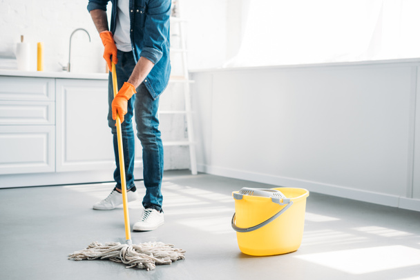 image recadrée de l'homme nettoyage sol dans la cuisine avec serpillière
 - Photo, image