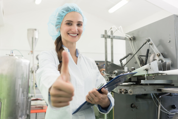 Portrait of happy woman manufacturing specialist showing thumbs up - Photo, Image