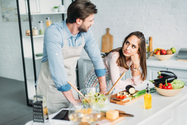 couple looking at each other at kitchen counter - Photo, Image