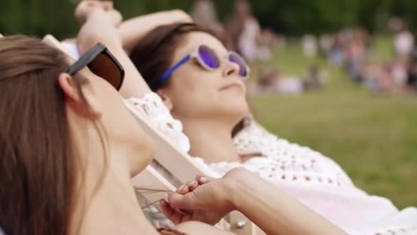 Kaksi nuorta naista ottaa aurinkoa kesällä
 - Materiaali, video
