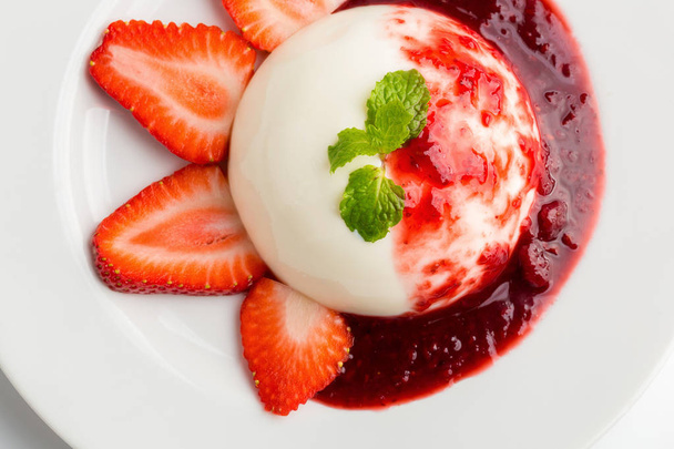 Delicious Italian dessert Panna Cotta with Strawberry, mint and berries sauce in plate. - Foto, Imagen