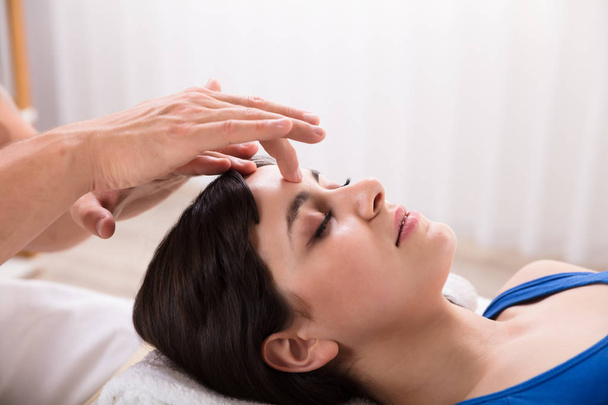 Close-up Of A Calm Young Woman Receiving Reiki Treatment In Spa - Foto, imagen