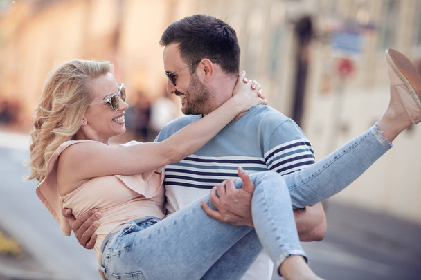 Jovem casal sorrindo e se divertindo ao ar livre em um encontro
. - Foto, Imagem