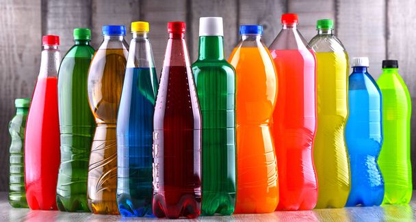 Plastikowe butelki różnych gazowanych napojów bezalkoholowych w różnych kolorach. - Zdjęcie, obraz