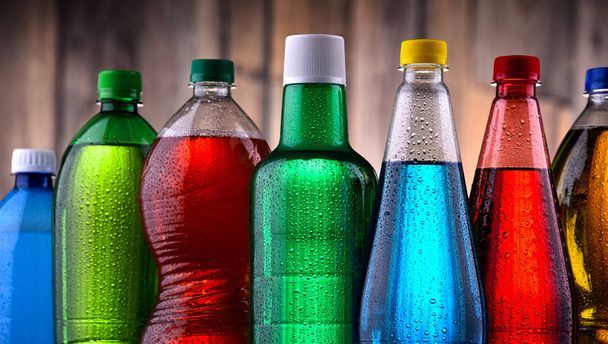 Plastikowe butelki różnych gazowanych napojów bezalkoholowych w różnych kolorach. - Zdjęcie, obraz