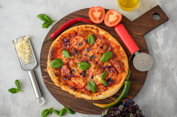 食材や料理のスパイス。トマト、チーズ、油、コショウ、バジル、オリーブ、ライト コンクリート背景においしいイタリアンピザ。平面図です。バナー - 写真・画像