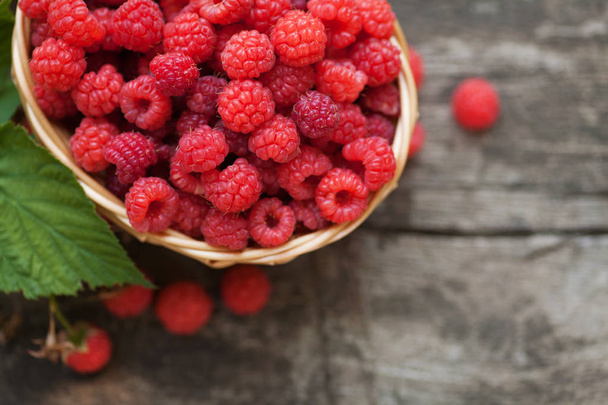 Ripe juicy raspberries on wooden background - Fotó, kép