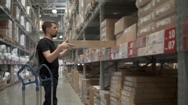 erwachsener Mann, befindet sich im Warenlager, wird er in den Warenkorb laden - Filmmaterial, Video