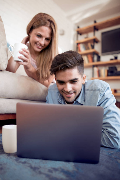 Ευτυχισμένο ζευγάρι κάνει online αγορές μαζί στο σπίτι. Έννοια αγάπης, τεχνολογία, Διαδίκτυο και άνθρωποι. - Φωτογραφία, εικόνα