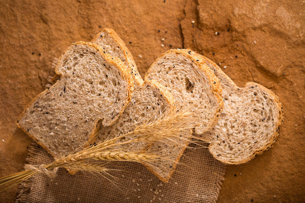 Нарезанный цельный хлеб пшеницы на темном фоне
 - Фото, изображение