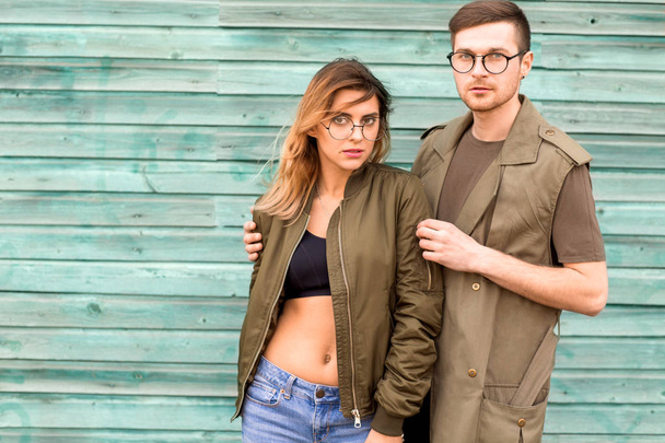 Modepaar posiert an grüner Holzwand - Foto, Bild
