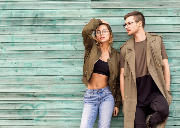 fashion couple standing posing near green wooden wall - Valokuva, kuva