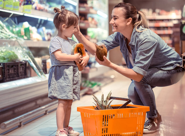Μαμά και κόρη της για ψώνια στο σούπερ μάρκετ, η έννοια των οικογενειακών σχέσεων και την υγιεινή διατροφή - Φωτογραφία, εικόνα